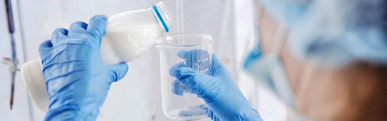 Laboratory Scientist Pouring Milk in a Lab Beaker