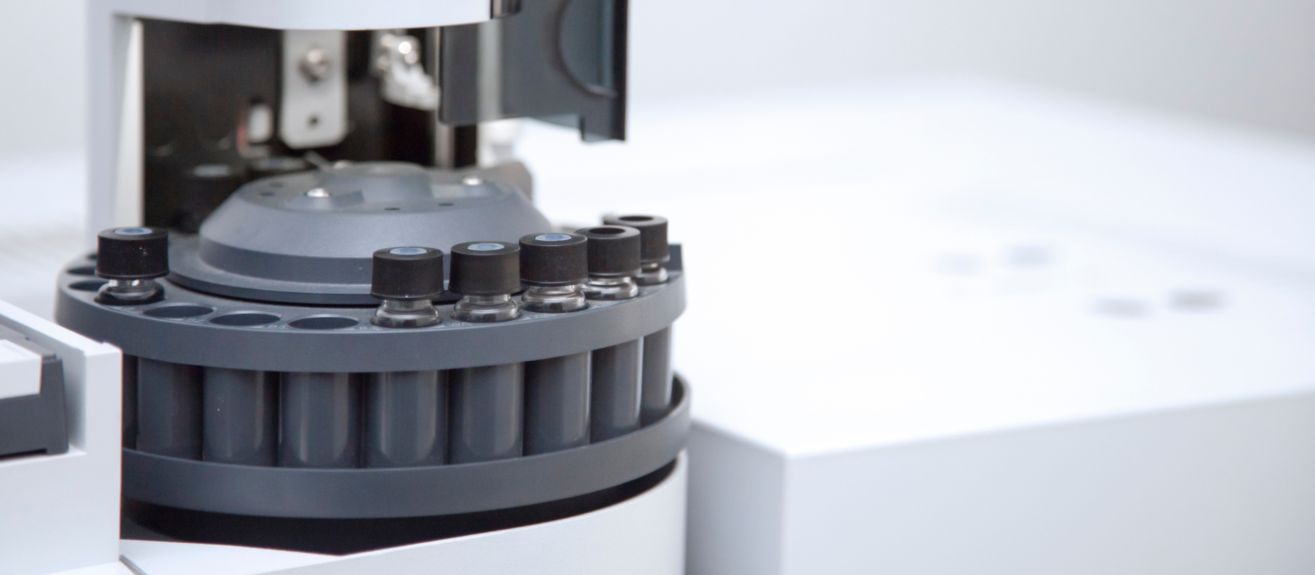 Close-up of a chromatography autosampler with vials and inserts
